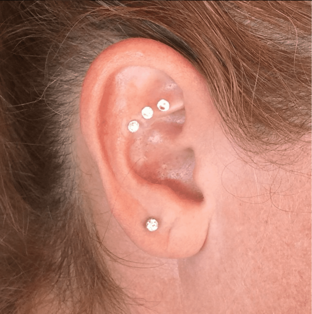 Swarovski Crystal ear seeds on client ear using auricular therapy